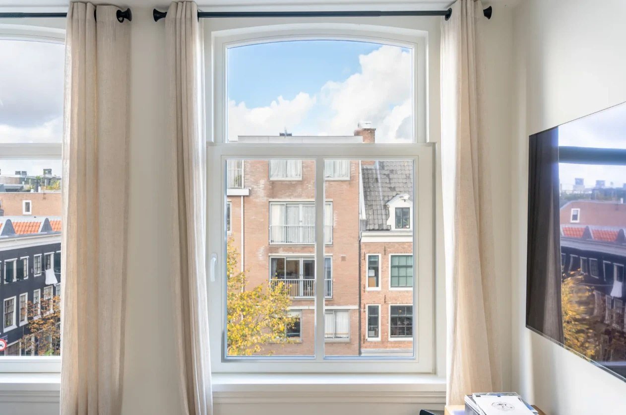 White window with an arched fixed top and an opening sash below