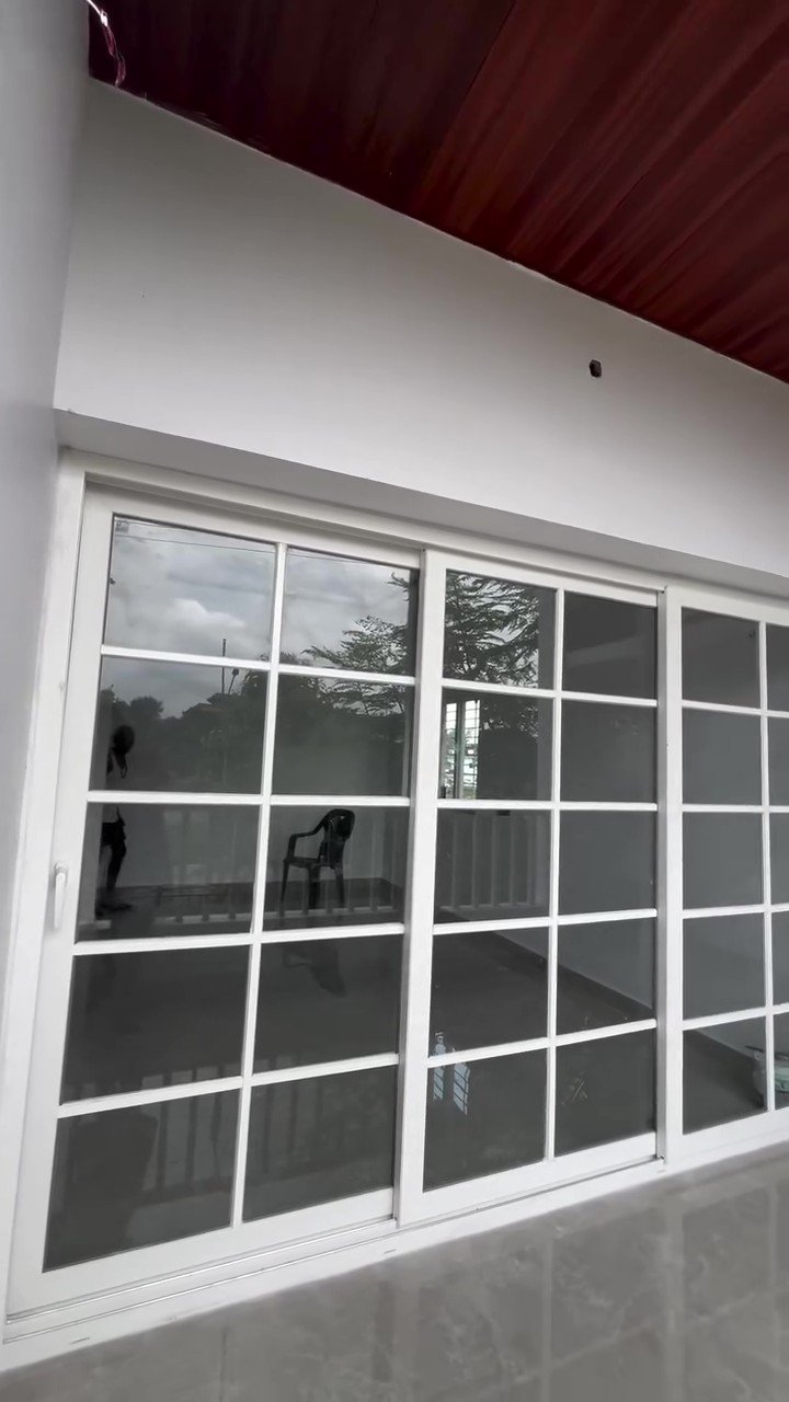 Newly fitted white UPVC sliding doors with grid bars opening onto a balcony